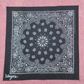 Black bandana with white paisley pattern on a pink background